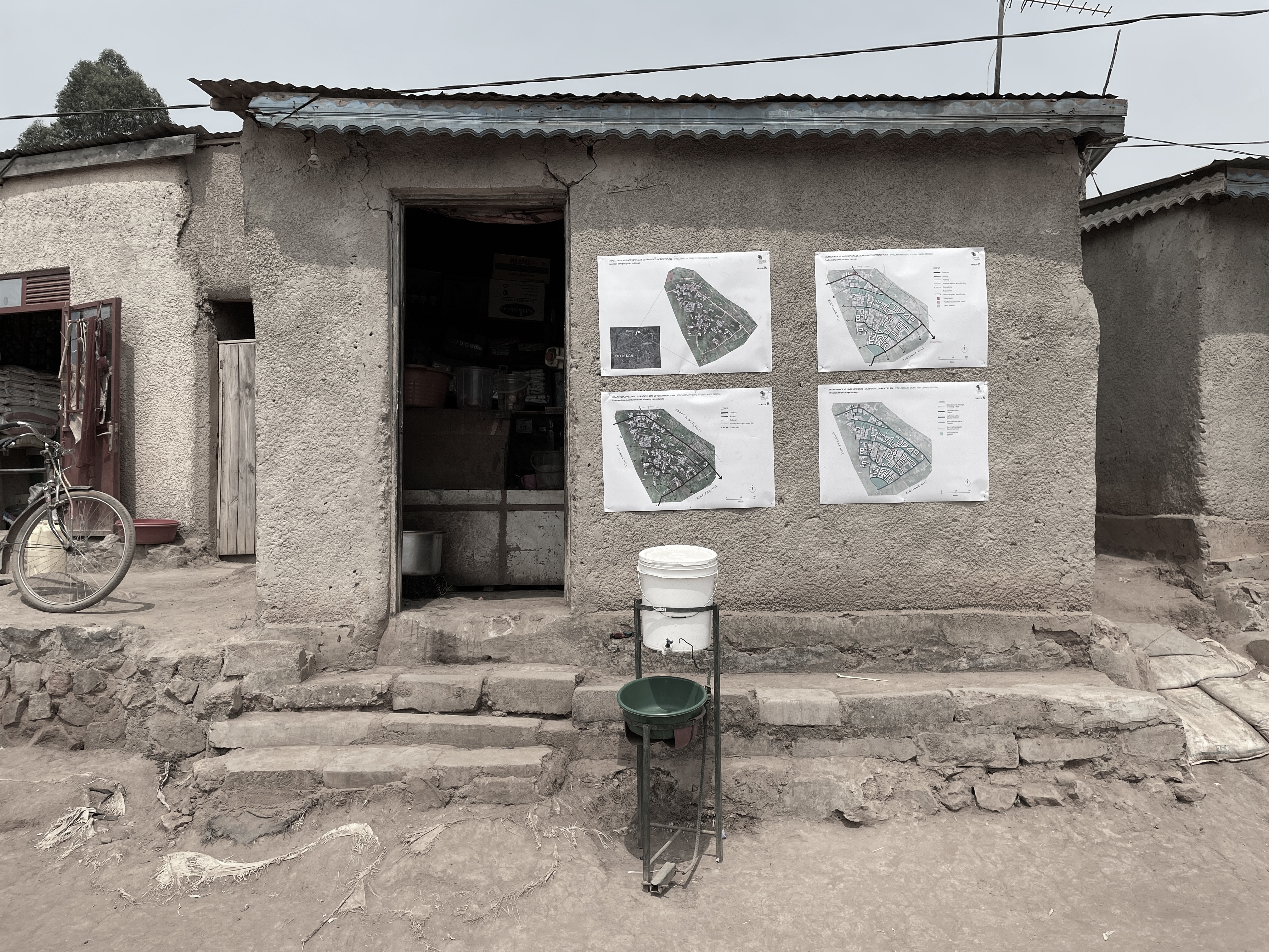 Architectural masterplans pinned to a building wall on site in Africa